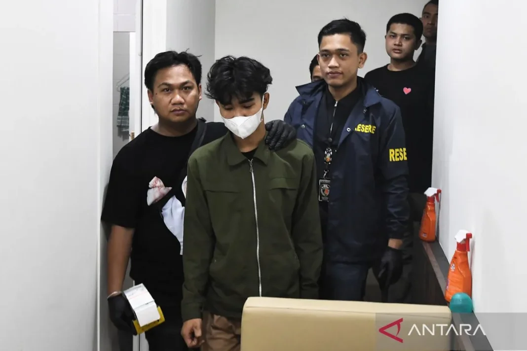 Personel Ditreskrimum Polda Metro Jaya menggiring seorang tersangka